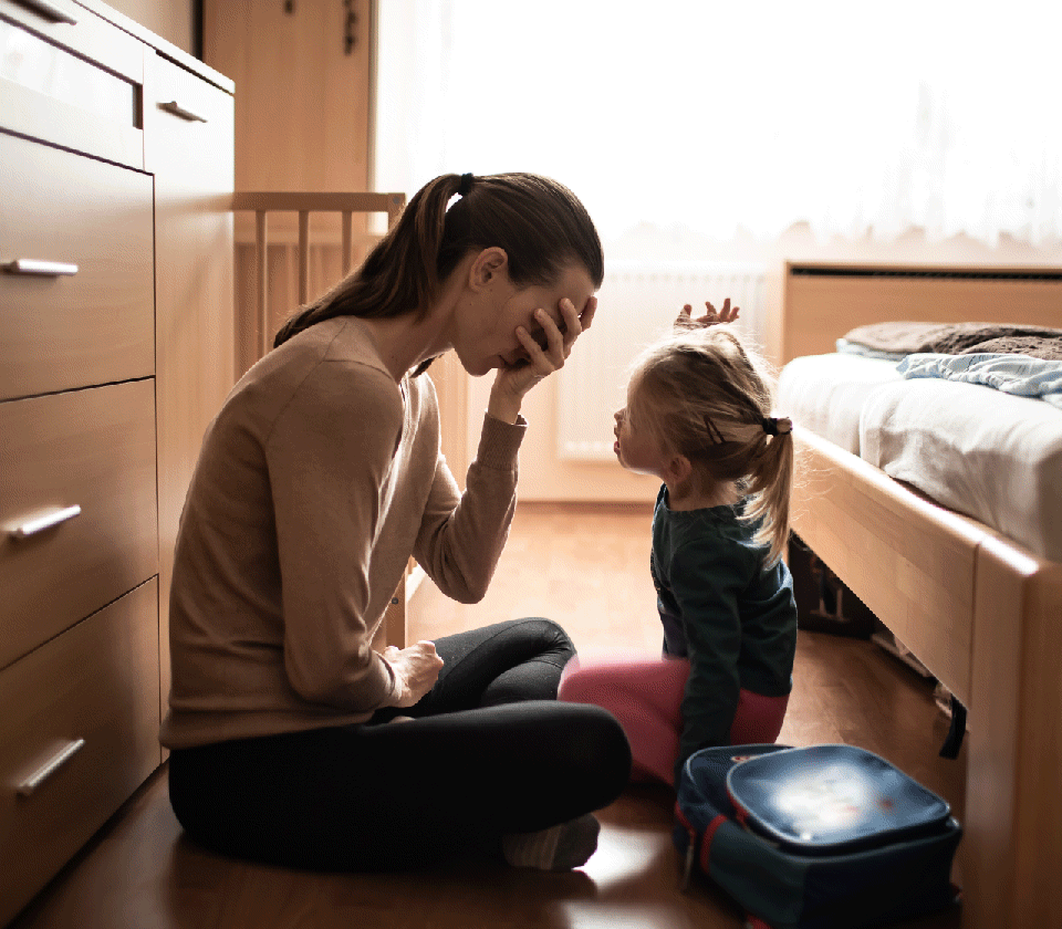 A mother sitting with her child in a bedroom
